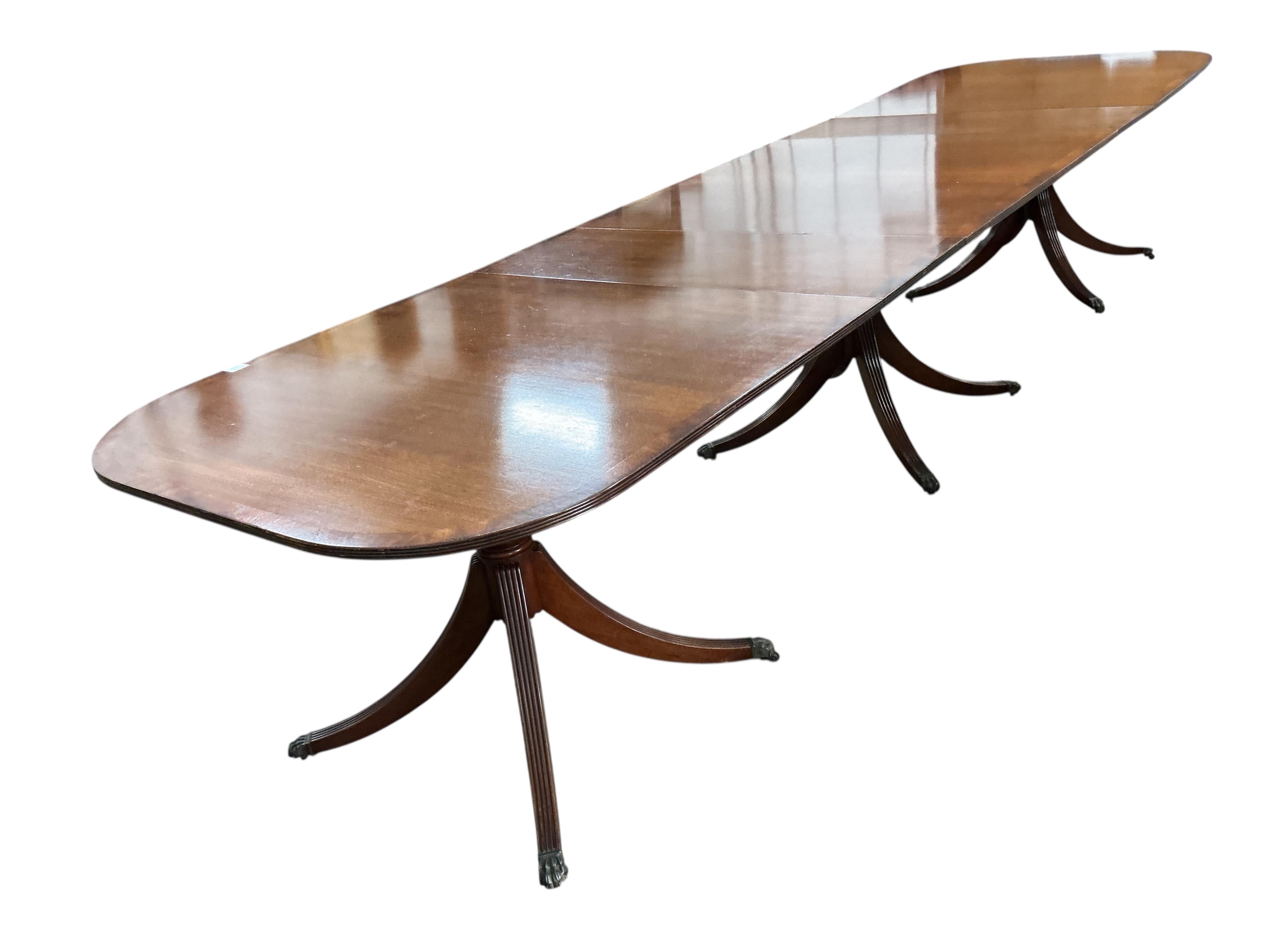 A reproduction George III style mahogany triple pillar extending dining table, width 500cm extended, two spare leaves, depth 108cm, height 75cm